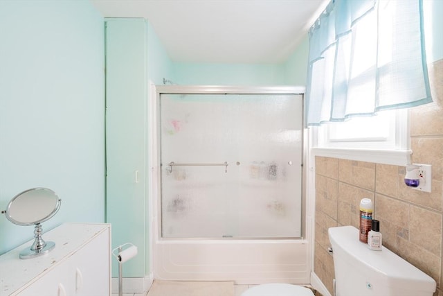 102 Gilman St, Somerville, MA 02145 - bathroom featuring toilet, bath / shower combo with glass door, and tile walls