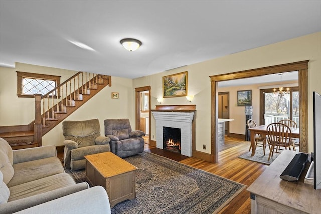 living room featuring hardwood / wood-style floors, a fireplace, and a chandelier