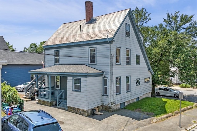 343 Cabot St, Beverly, MA 01915 - rear view of property featuring a chimney, a porch, and a lawn