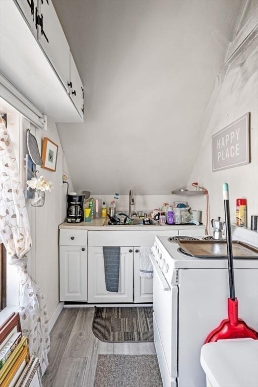 343 Cabot St, Beverly, MA 01915 - kitchen featuring vaulted ceiling, light wood-type flooring, light countertops, white cabinetry, and white range with electric cooktop