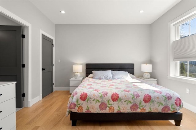 bedroom featuring multiple windows, light wood finished floors, baseboards, and recessed lighting