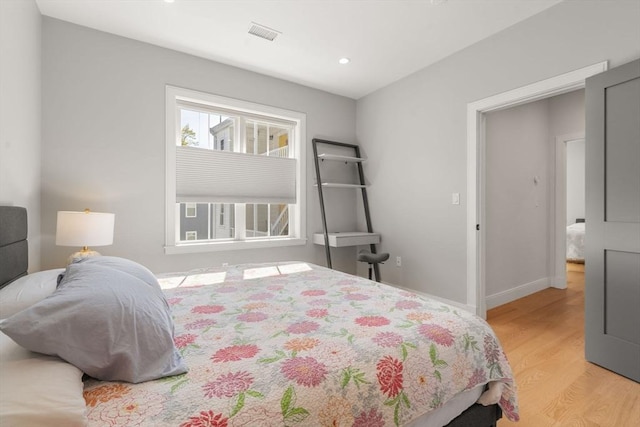 bedroom with light wood-style floors, recessed lighting, and baseboards