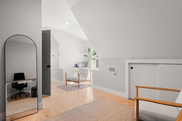 interior space featuring wood finished floors, baseboards, vaulted ceiling, and recessed lighting