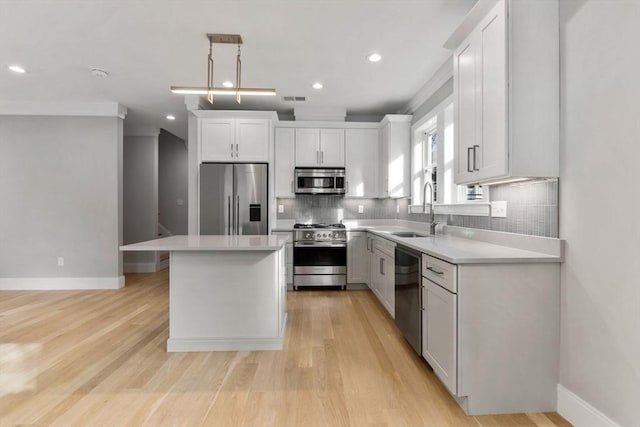 kitchen with sink, a center island, stainless steel appliances, pendant lighting, and white cabinets