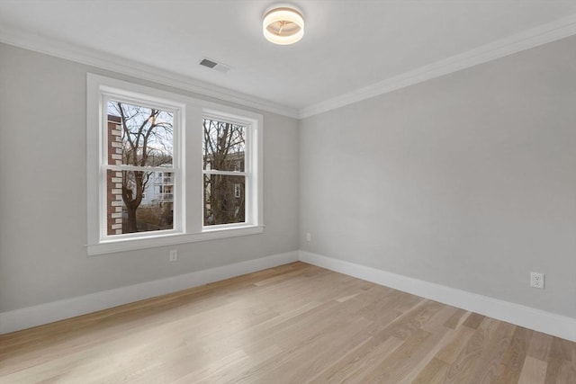 spare room featuring ornamental molding and light wood-type flooring