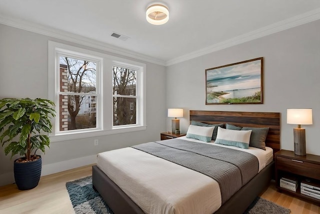 bedroom featuring crown molding and light hardwood / wood-style flooring