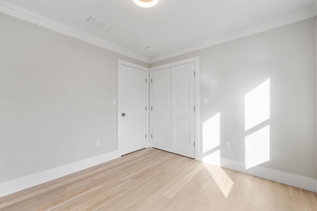 spare room featuring light hardwood / wood-style floors and ornamental molding