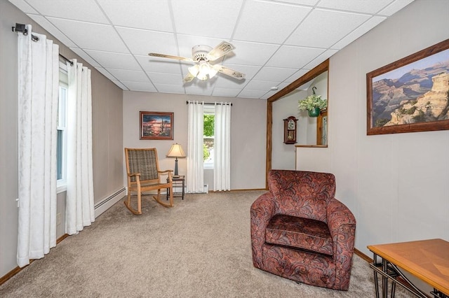 sitting room with a paneled ceiling, ceiling fan, carpet floors, a baseboard heating unit, and baseboards