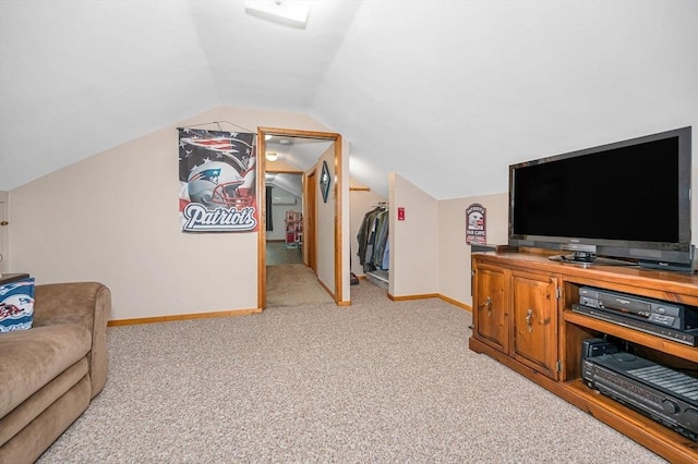 living area with light colored carpet, lofted ceiling, and baseboards