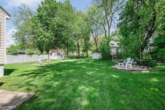 view of yard featuring a storage shed, an outbuilding, and a patio area