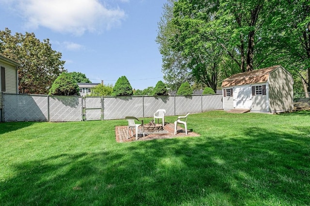 view of yard with a storage unit, an outdoor fire pit, and an outdoor structure