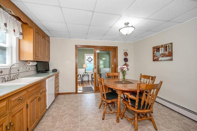dining room with a drop ceiling, plenty of natural light, a baseboard heating unit, and baseboards