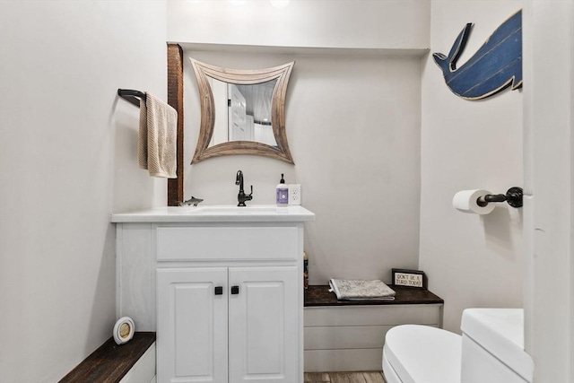 bathroom featuring hardwood / wood-style flooring, vanity, and toilet