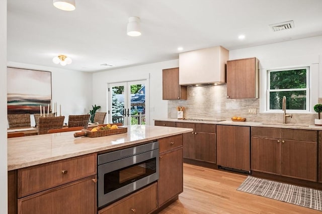1 Archer St, Swampscott, MA 01907 - kitchen featuring stainless steel microwave, light wood-type flooring, backsplash, light stone counters, and recessed lighting