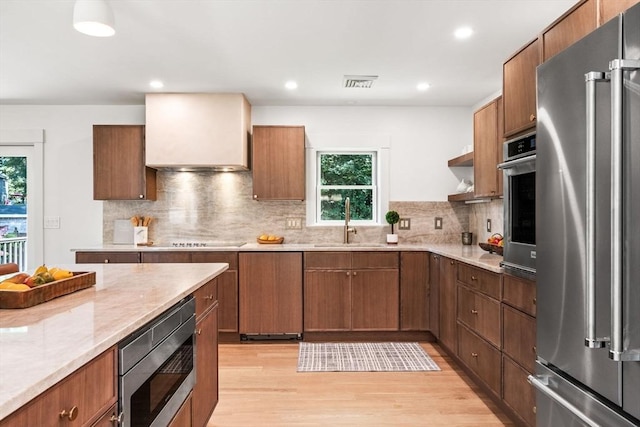 1 Archer St, Swampscott, MA 01907 - kitchen featuring appliances with stainless steel finishes, healthy amount of natural light, light wood-type flooring, decorative backsplash, and recessed lighting