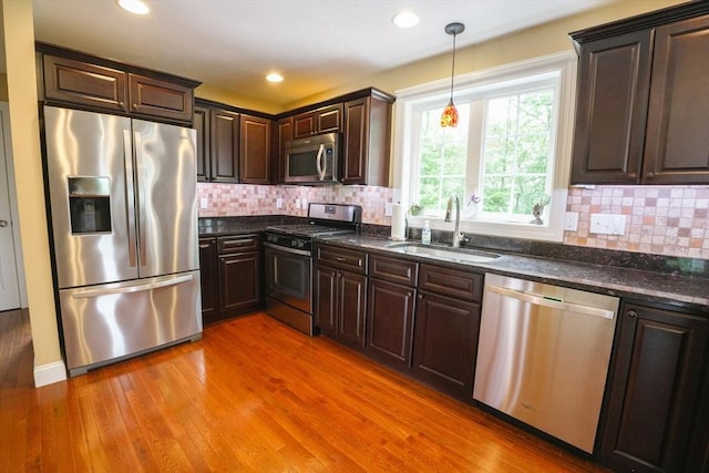 9 Gideon Ln, Shirley, MA 01464 - kitchen featuring appliances with stainless steel finishes, a sink, dark brown cabinets, light wood-style floors, and dark stone counters