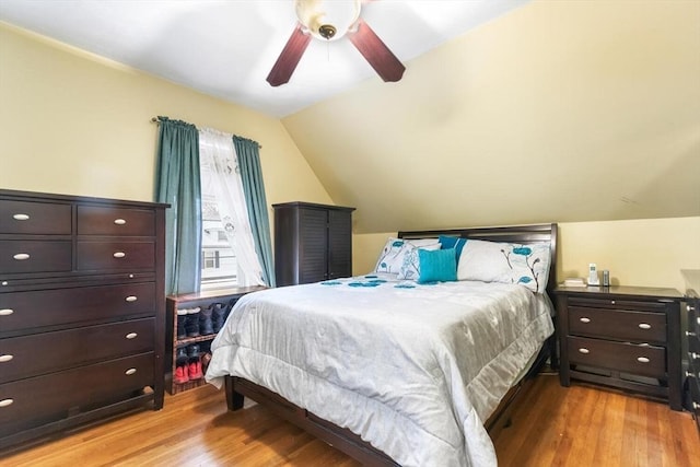 bedroom with vaulted ceiling, light hardwood / wood-style floors, and ceiling fan