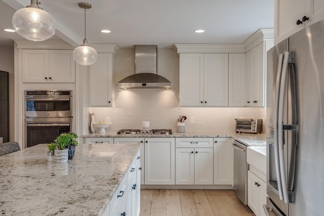 41 Pleasant St, Holliston, MA 01746 - kitchen with appliances with stainless steel finishes, wall chimney exhaust hood, white cabinetry, decorative backsplash, and recessed lighting