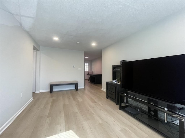 living room featuring a textured ceiling and light wood-type flooring