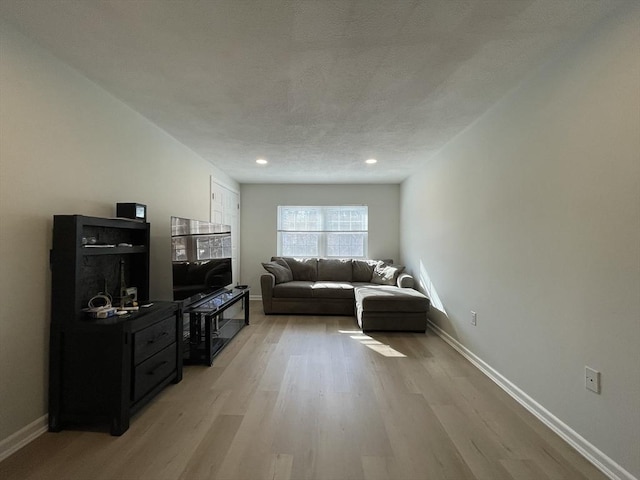 living room featuring a textured ceiling and light hardwood / wood-style floors