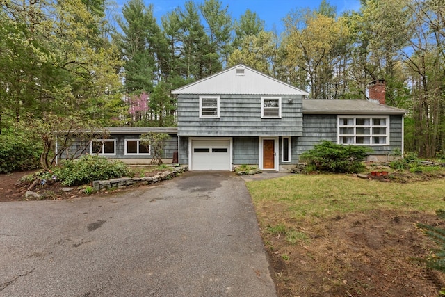 9 Flagg Rd, Acton, MA 01720 - split level home featuring a garage, a chimney, driveway, and view of wooded area