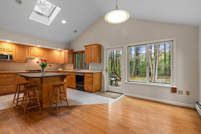 9 Flagg Rd, Acton, MA 01720 - kitchen with dishwasher, stainless steel microwave, a skylight, a breakfast bar, and light wood-style floors