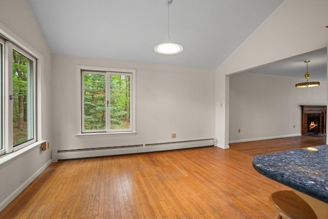 9 Flagg Rd, Acton, MA 01720 - living room with vaulted ceiling, hardwood / wood-style flooring, a baseboard radiator, baseboards, and a brick fireplace
