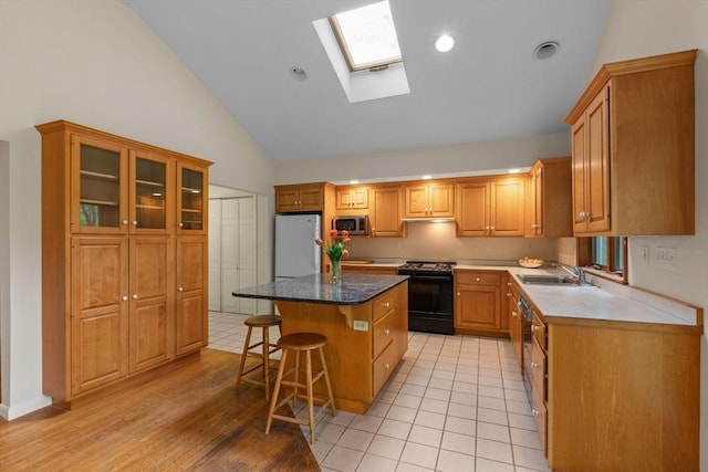 9 Flagg Rd, Acton, MA 01720 - kitchen featuring black gas stove, white fridge, stainless steel microwave, a kitchen breakfast bar, and a kitchen island