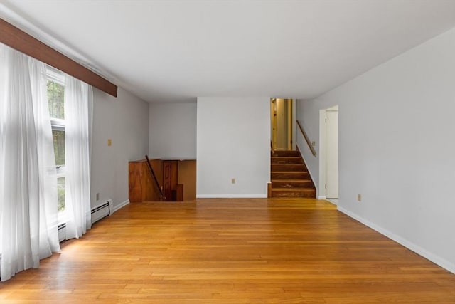 9 Flagg Rd, Acton, MA 01720 - unfurnished room with a baseboard heating unit, light wood-style flooring, baseboards, and stairway