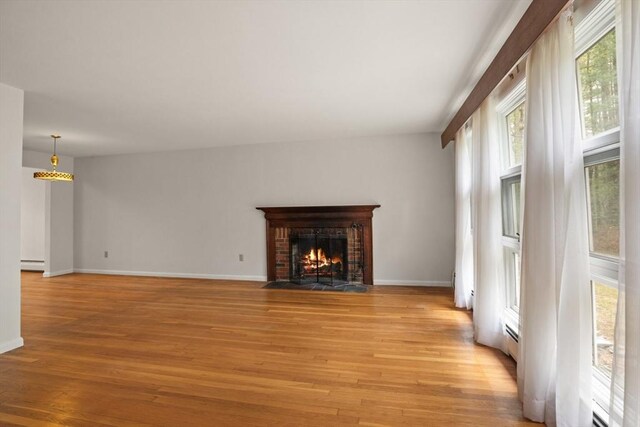 9 Flagg Rd, Acton, MA 01720 - unfurnished living room featuring light wood-style flooring, a baseboard radiator, a fireplace, baseboards, and baseboard heating