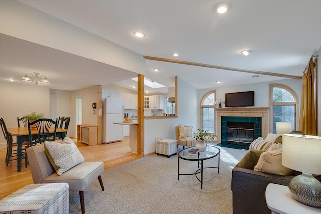 living room with lofted ceiling and a tile fireplace