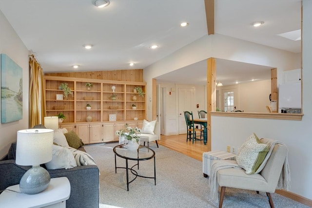 living room with vaulted ceiling with beams, built in features, and light wood-type flooring