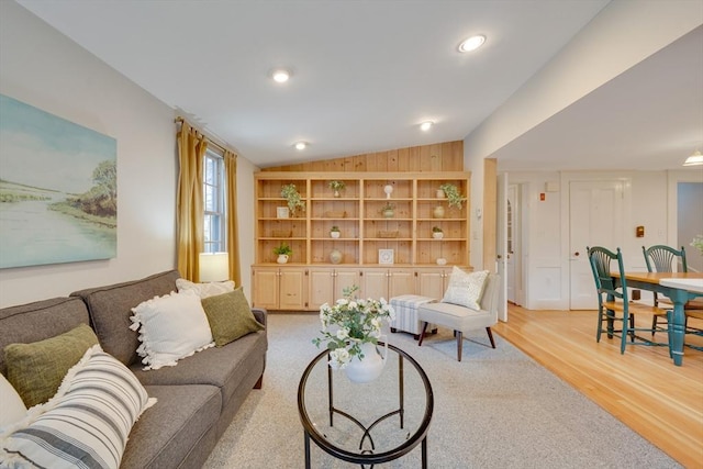 living room featuring vaulted ceiling and light hardwood / wood-style flooring