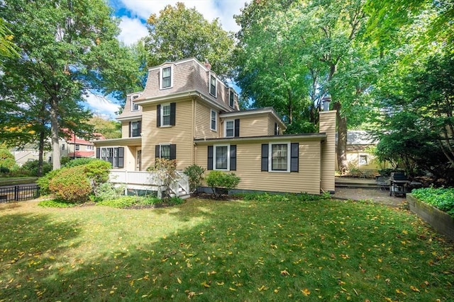 rear view of property featuring a yard