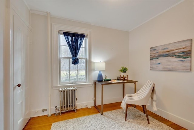 office space featuring hardwood / wood-style floors, ornamental molding, and radiator heating unit