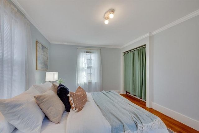 bedroom with ornamental molding and wood-type flooring