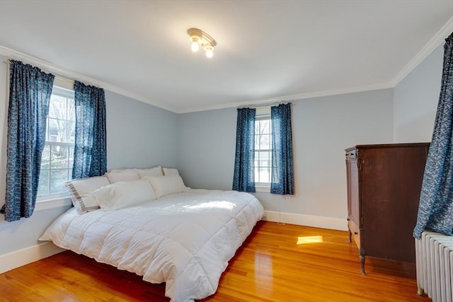 bedroom featuring hardwood / wood-style flooring, crown molding, and radiator