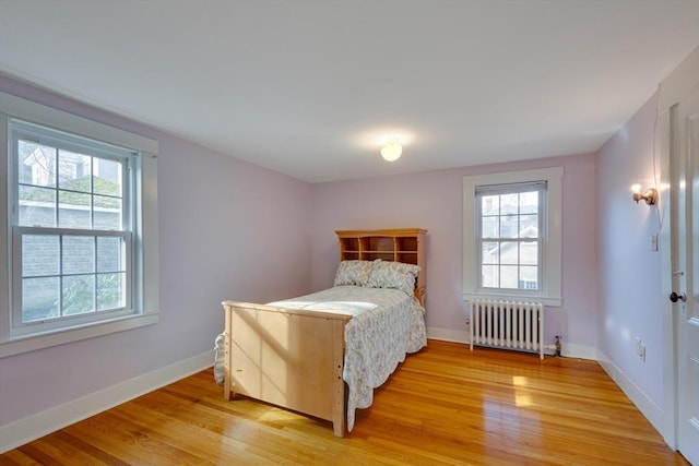 bedroom featuring hardwood / wood-style floors and radiator heating unit