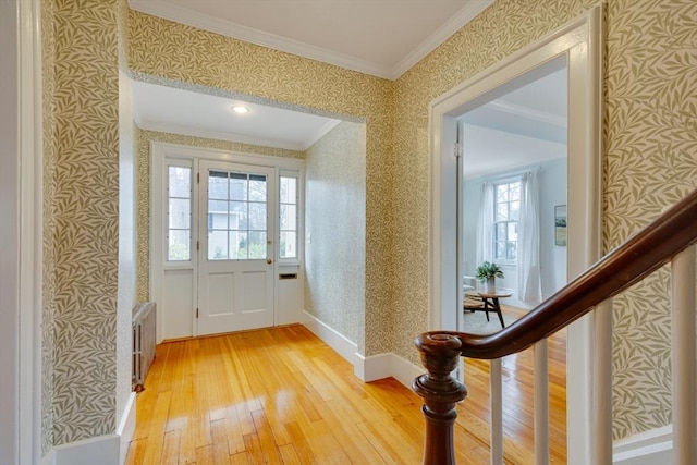 entryway with ornamental molding, light hardwood / wood-style flooring, and radiator heating unit