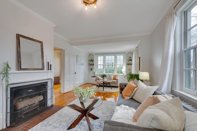 living room with crown molding, hardwood / wood-style floors, and built in features