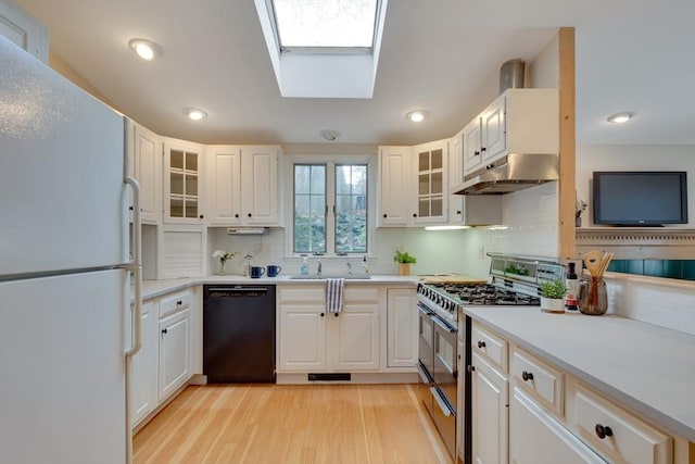 kitchen with white refrigerator, white cabinetry, dishwasher, and range with two ovens