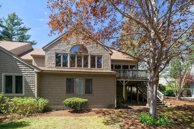 back of house with roof with shingles, stairs, and a wooden deck