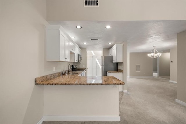 kitchen featuring baseboards, light stone counters, visible vents, a sink, and stainless steel appliances