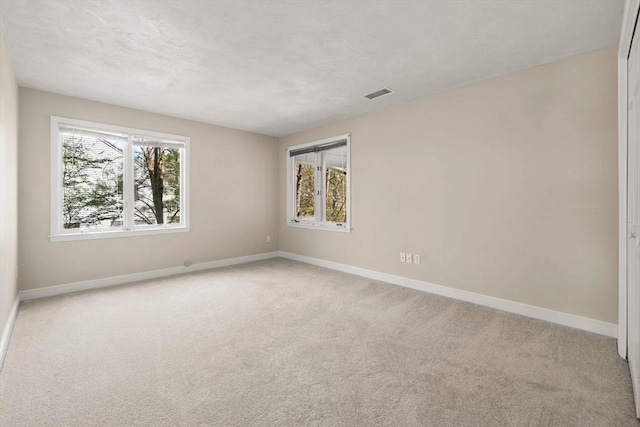 unfurnished room featuring light carpet, baseboards, and visible vents
