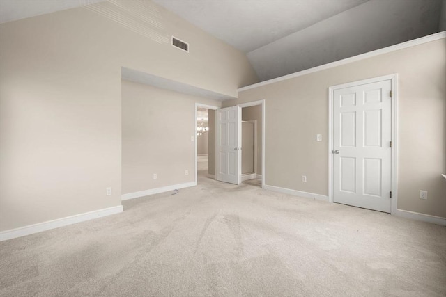 unfurnished bedroom with vaulted ceiling, carpet, visible vents, and baseboards