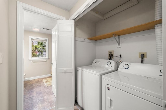 washroom with washing machine and dryer, laundry area, baseboards, and visible vents