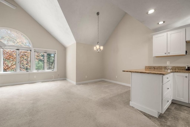 kitchen featuring light carpet, lofted ceiling, baseboards, and recessed lighting