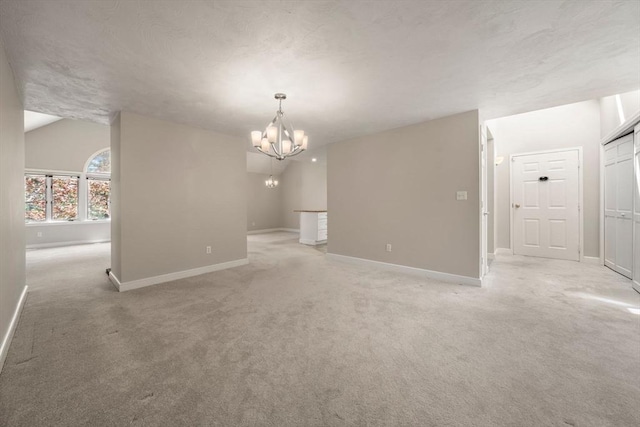 empty room with light colored carpet, an inviting chandelier, and baseboards