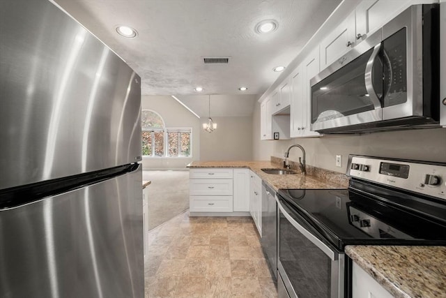 kitchen with lofted ceiling, visible vents, a sink, white cabinetry, and stainless steel appliances