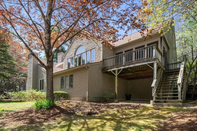 back of house featuring stairway, a chimney, and a deck